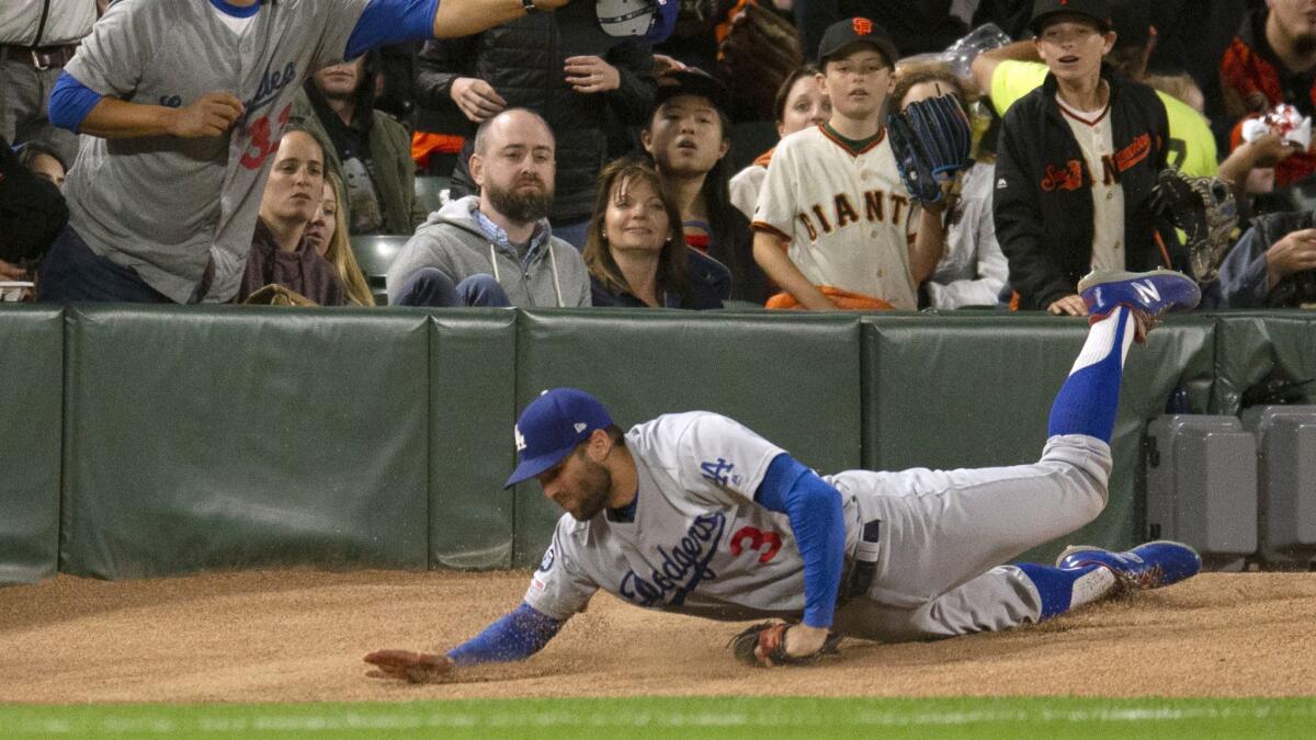 Dodgers left fielder Chris Taylor trips over the bullpen pitcher's mound while chasing a foul ball against the San Francisco Giants on June 7.