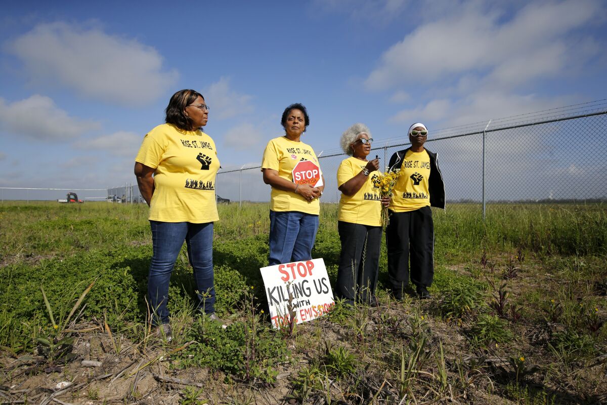 FILE - Myrtle Felton, from left, Sharon Lavigne, Gail LeBoeuf and Rita Cooper, members of RISE St. James, conduct a live stream video on property owned by Formosa on March 11, 2020, in St. James Parish, La. Residents of a Louisiana parish located in the heart of a cluster of polluting petrochemical factories filed a federal lawsuit Tuesday, March 21, 2023, raising allegations of civil rights, environmental justice and religious liberty violations. (AP Photo/Gerald Herbert, File)