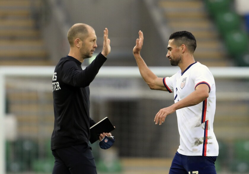 L'entraîneur américain Gregg Berhalter, à gauche, tape sur cinq avec le milieu de terrain américain Sebastian Lletget 