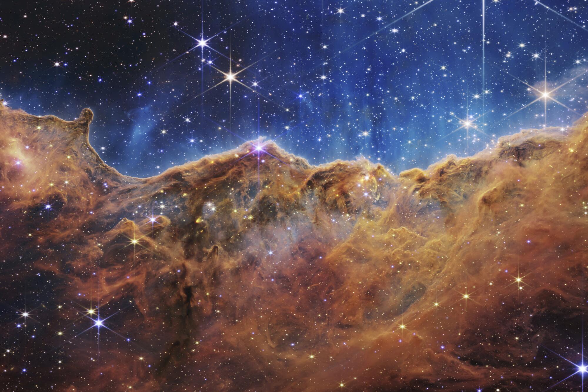 This image released by NASA shows the edge of a nearby, young, star-forming region NGC 3324 in the Carina Nebula. 