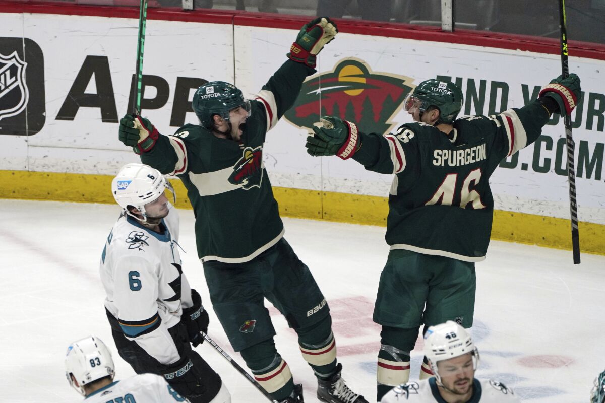 San Jose Sharks' Ryan Merkley (6) skates past Minnesota Wild's Kevin Fiala, center, and Jared Spurgeon (46) as they celebrate Spurgeon's game-winning goal in overtime of an NHL hockey game, Sunday, April 17, 2022, in St. Paul, Minn. The Wild won 5-4 in overtime. Spurgeon also scored in the first period and Fail scored in the third period to tie the game. (AP Photo/Jim Mone)