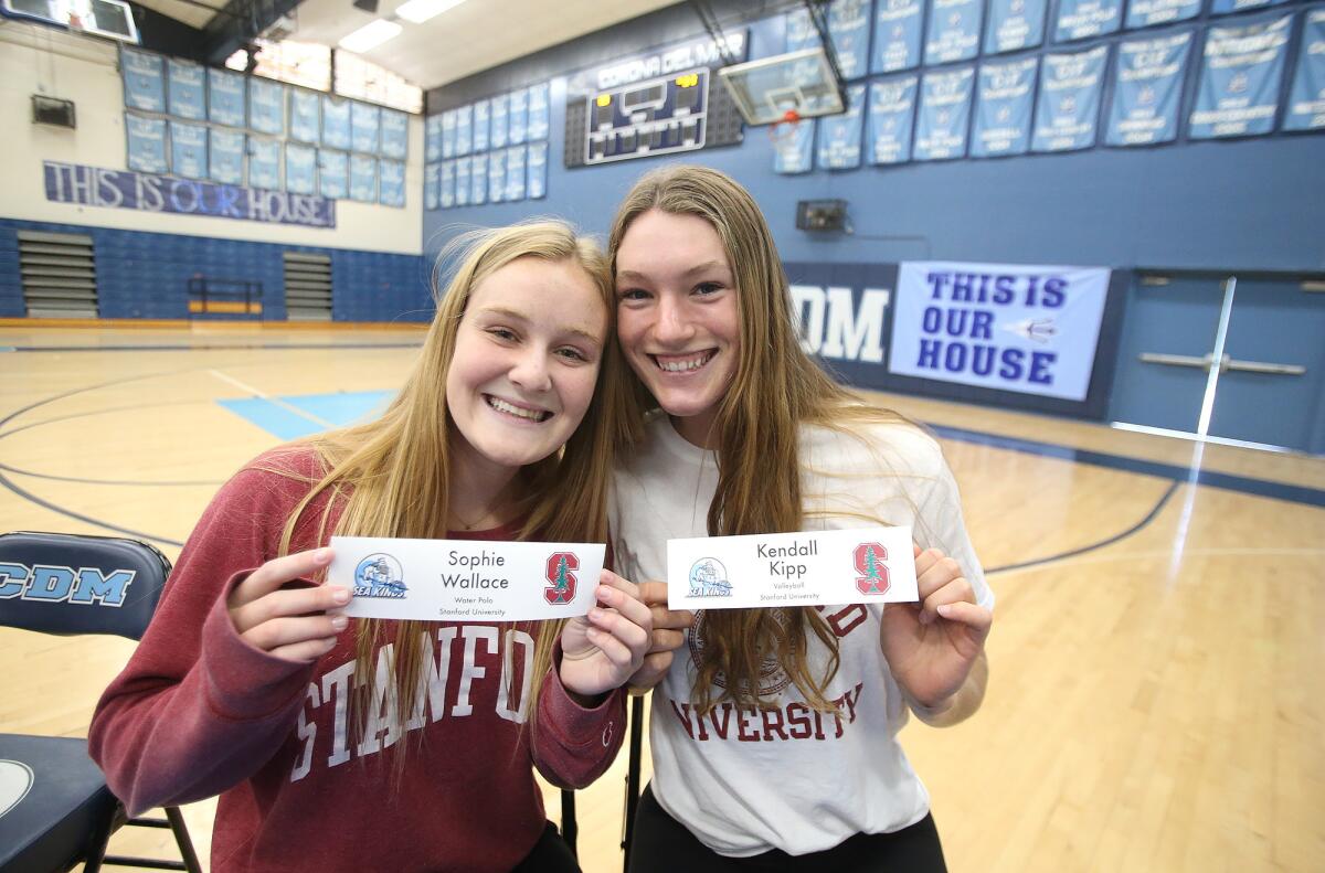 Sophie Wallace, left, and Kendall Kipp, who are both going to Stanford to play women's water polo and women's volleyball, respectively, pose for a photo during the Corona del Mar commitment ceremony in the main gym on Wednesday.