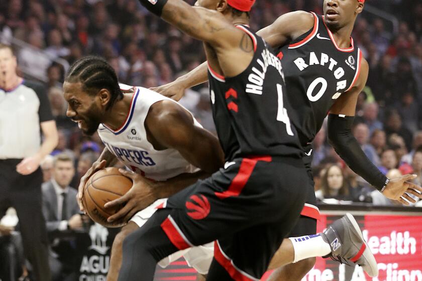 LOS ANGELES, CALIF. - NOV. 11, 2019. Clippers forward Kawhi Leonard splits the defnse of Raptors Rondae Hollis-Jefferson and Terence Dsvis II in the first quarter at Staples Center in Los Angeles on Monday night, Nov. 11, 2019. (Luis Sinco/Los Angeles Times)