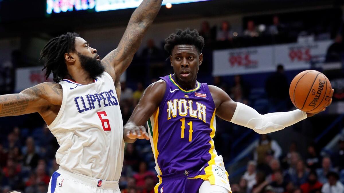 New Orleans Pelicans guard Jrue Holiday passes around Clippers center DeAndre Jordan on Sunday at the Smoothie King Center.