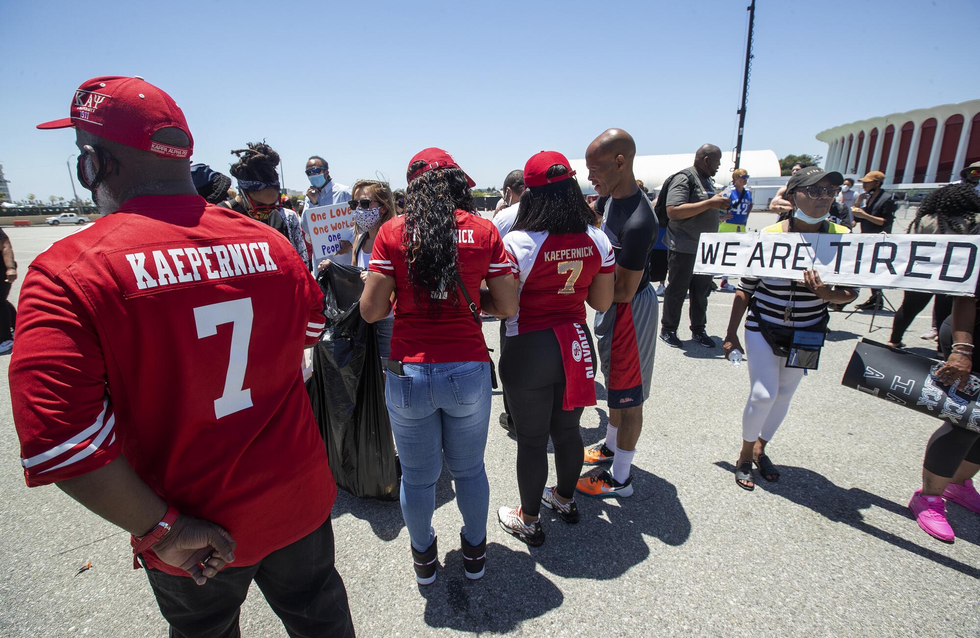 Katie Fuller, 74, of Inglewood, right, joins protesters in Inglewood, demanding that the NFL apologize to Colin Kaepernick.