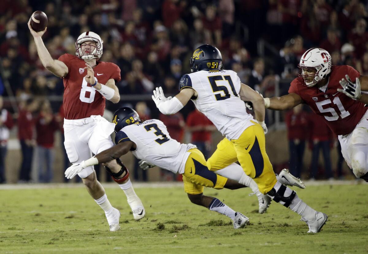 Stanford's Kevin Hogan throws under pressure from California's Cameron Walker (3) and Cameron Saffle (51).