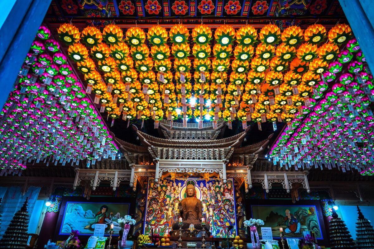 A Buddha statue and colorful lanterns at the 1,000-year-old Samhwasa, a temple in the Muneung Valley in South Korea.