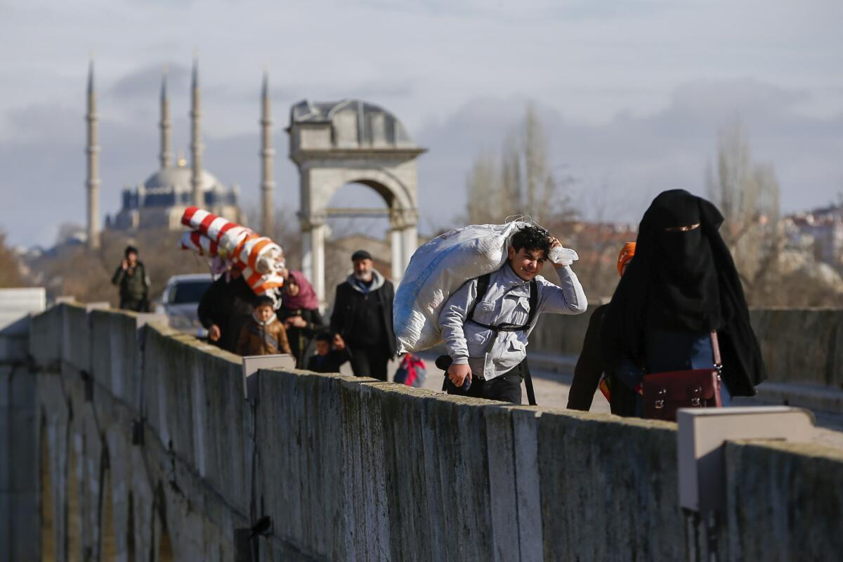 Migrants walk across a bridge near the Turkish-Greek border on Thursday.