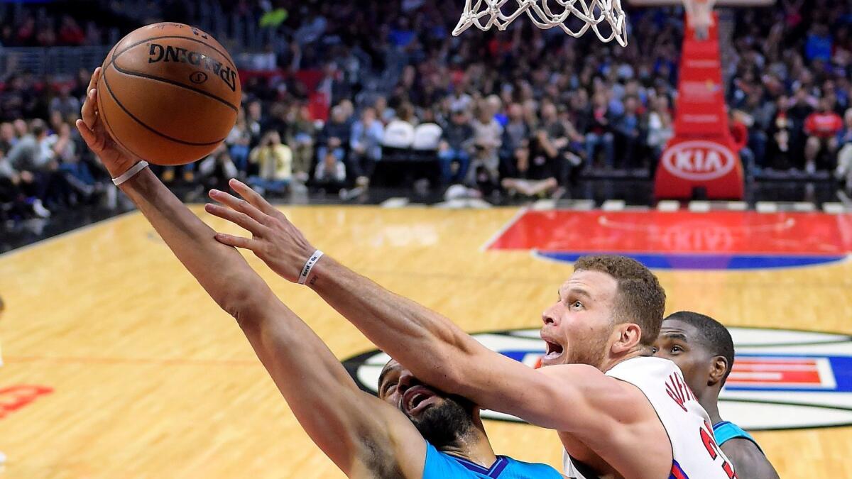 Clippers' Blake Griffin and Charlotte's guard Nicolas Batum reach for a rebound on Feb. 26.