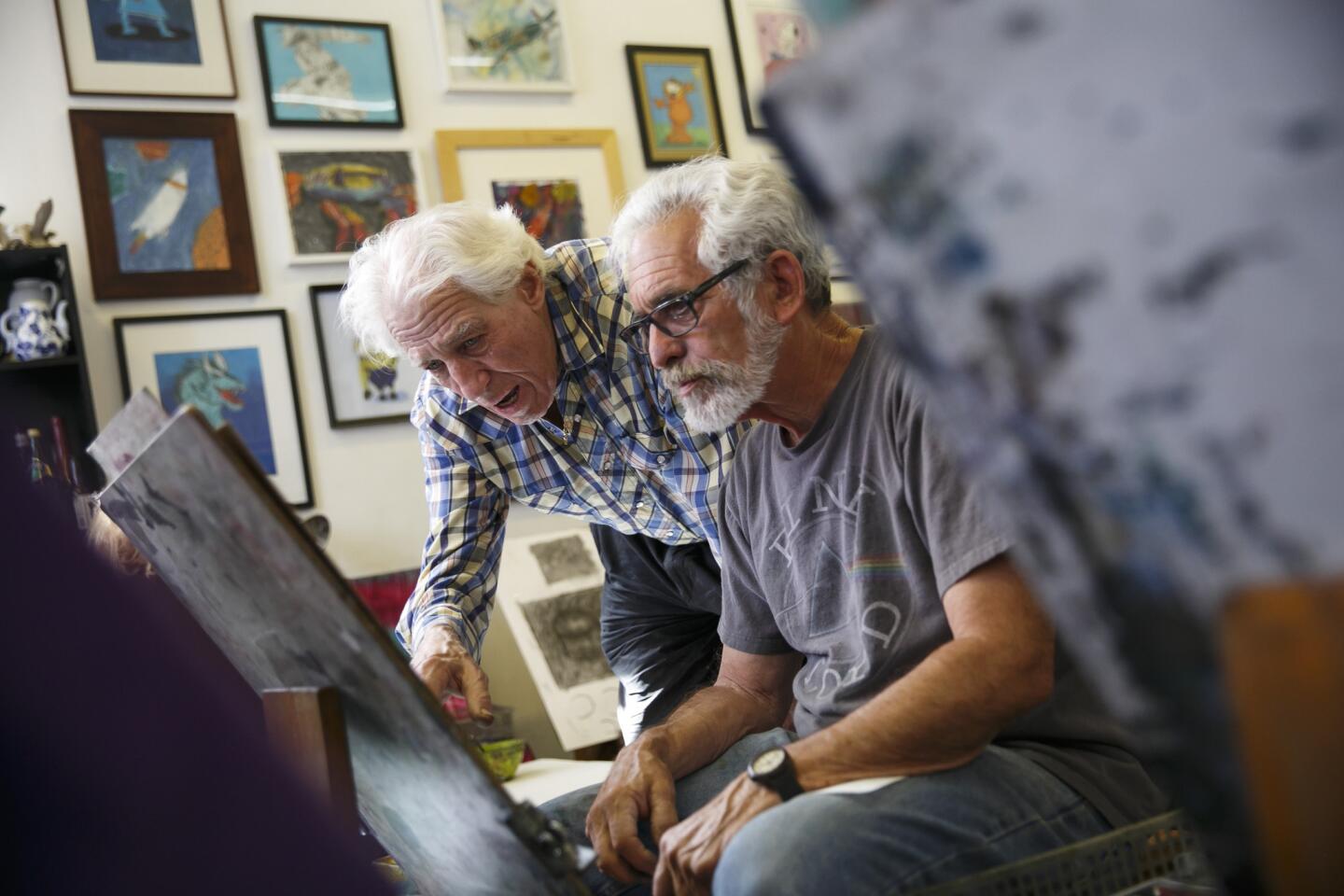 Paul Eventoff, left, helps Gary Silk with his art during a class at the Wizard of Art, which just celebrated its 20th anniversary in Los Feliz.