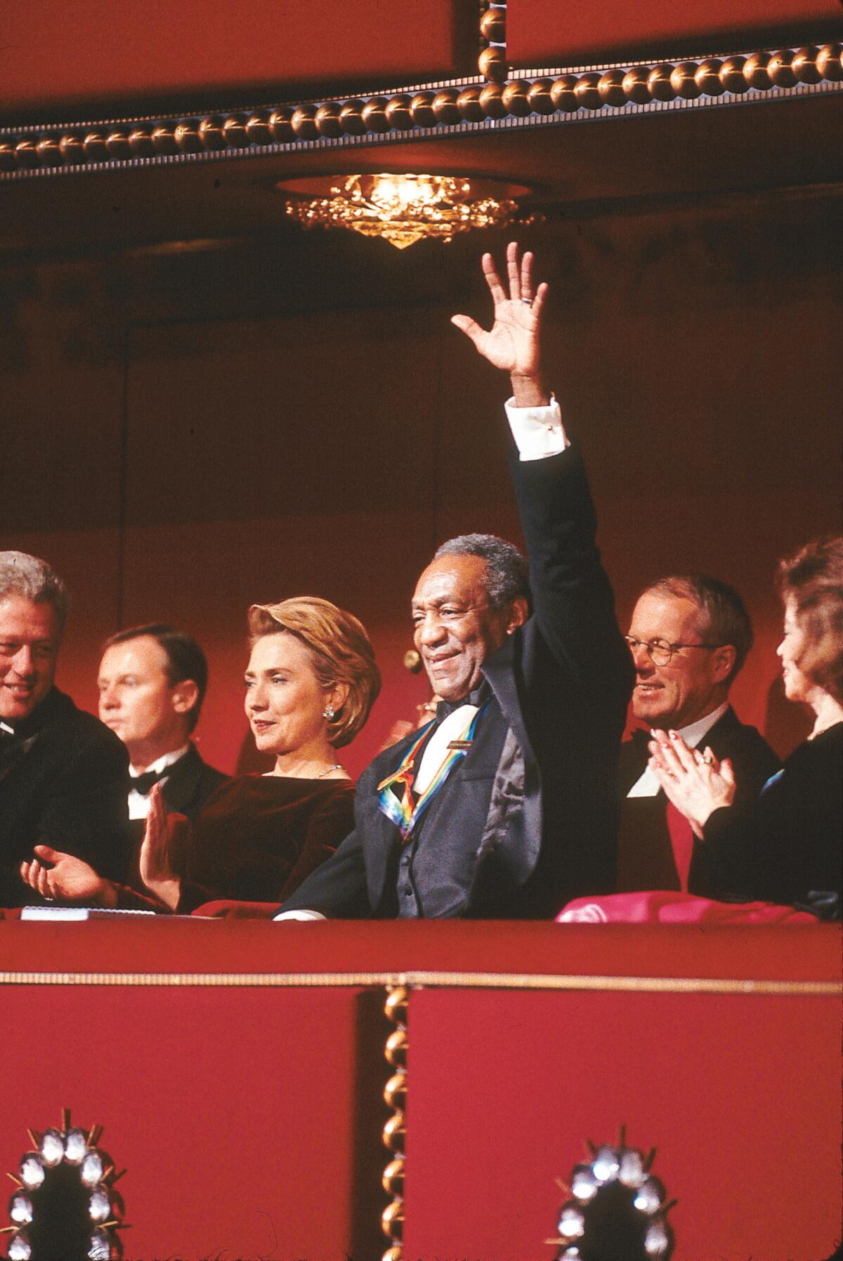 Bill Clinton (partially viewed on the left), Hillary Clinton and Bill Cosby watch as Cosby is the celebrant of the 1998 Kennedy Center Honors.