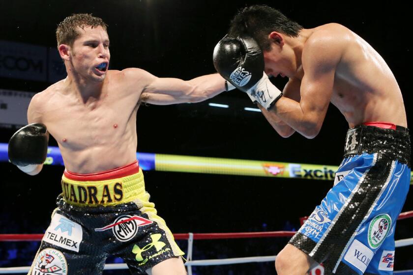 Mexican champion Carlos Cuadras, left, lands a left to the head of Koki Eto during their WBC super-flyweight title bout on Nov. 28, 2015.