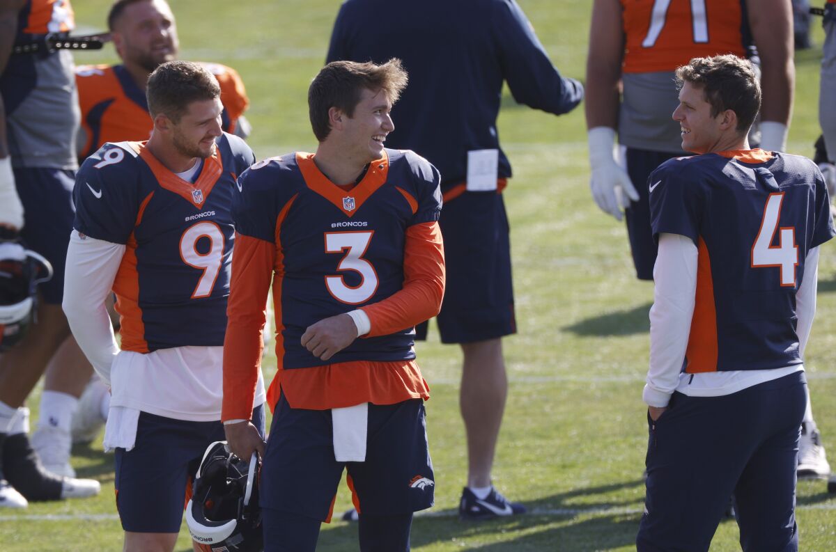 FILE - Denver Broncos quarterback Drew Lock, center, jokes with backup quarterbacks Jeff Driskel, left, and Brett Rypien during an NFL football practice in Englewood, Colo., in this Monday, Aug. 31, 2020, file photo. The Broncos activated three quarterbacks—starter Lock and backups Rypien and Blake Bortles—from the COVID-19 list Tuesday, Dec. 1, 2020, to insure that the team will not be without quarterbacks on the roster for the game against the Chiefs in Kansas City on Sunday as the Broncos were last Sunday when hosting the New Orleans Saints. (AP Photo/David Zalubowski, File)
