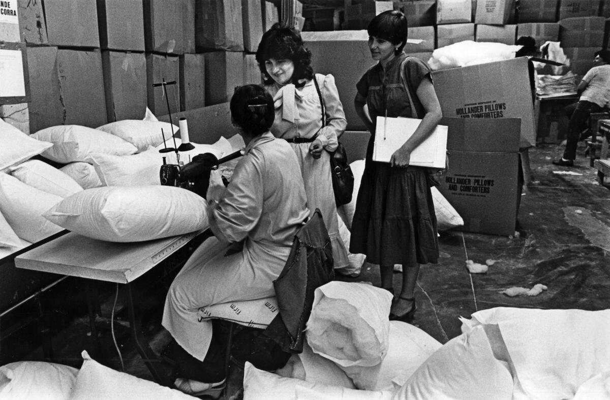 Cristina Ramirez, center, an organizer for the International Ladies Garment Workers Union, visits workers at a factory.