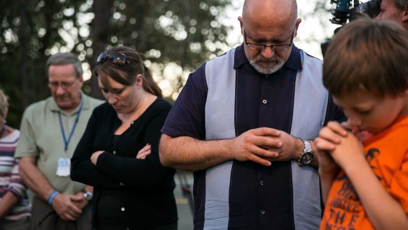 Community members gather to pray at a makeshift memorial outside Snyder Hall where the Umpqua Community College mass shootings occurred in Roseburg, Ore.