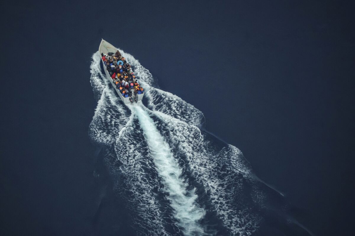 Migrants navigate on an overcrowded wooden boat in the Central Mediterranean Sea between North Africa and the Italian island of Lampedusa, Saturday, Oct. 2, 2021, as seen from aboard the humanitarian aircraft Seabird. At least 23,000 people have died or disappeared trying to reach Europe since 2014, according to the United Nations' migration agency. Despite the risks, many migrants say they'd rather die trying to reach Europe than be returned to Libya. (AP Photo/Renata Brito)