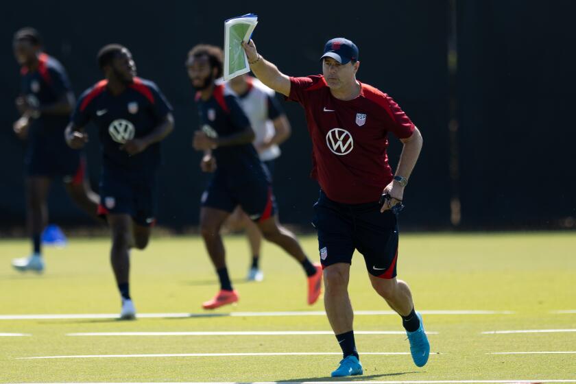 U.S. men's soccer coach Mauricio Pochettino raises his arm and leans forward as he leads the team through training