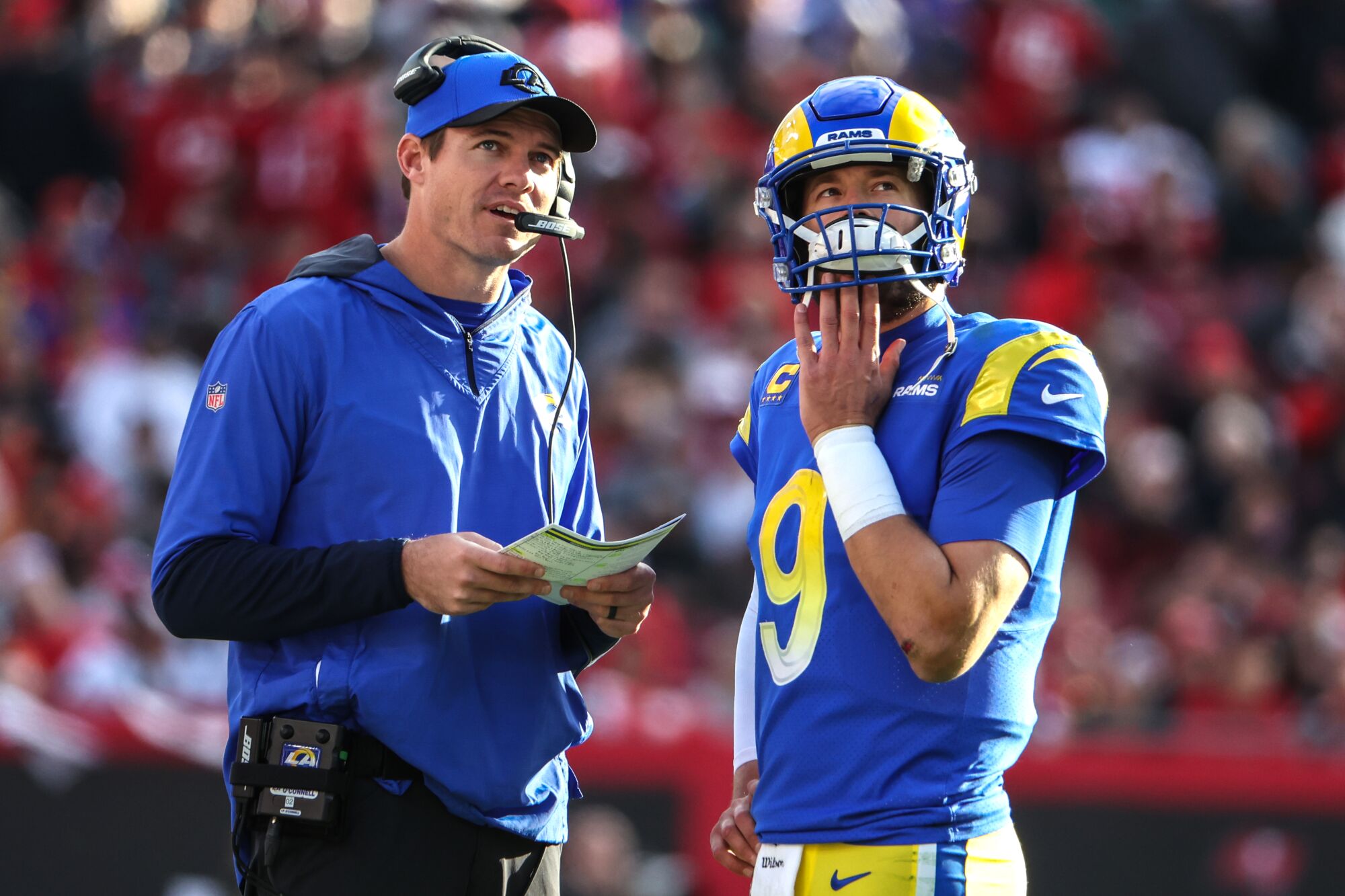 Rams coach Zac Robinson talks with quarterback Mattew Stafford.