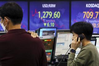 A currency trader talks on the phone near a screen showing the foreign exchange rate between U.S. dollar and South Korean won, center, at a foreign exchange dealing room in Seoul, South Korea, Thursday, Dec. 22, 2022. Shares advanced in Asia on Thursday after a rally on Wall Street as investors welcomed a report showing U.S. consumer confidence is holding up despite the Federal Reserve’s campaign to fight inflation by raising interest rates. (Choi Jin-suk/Newsis via AP)