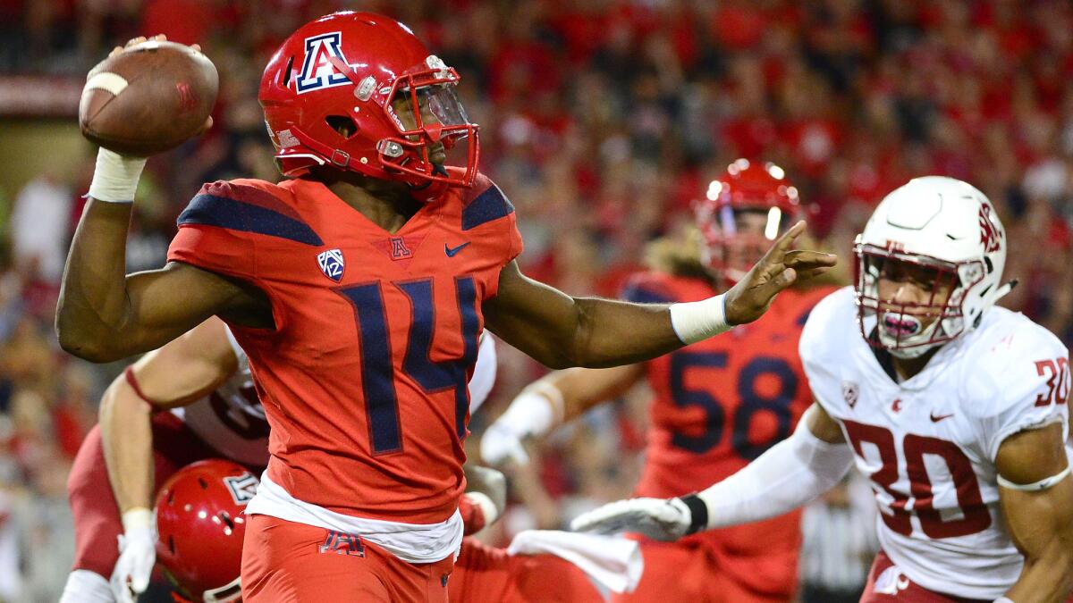 Arizona quarterback Khalil Tate prepares to pass under pressure from Washington State defensive lineman Nnamdi Oguayo during the first half Saturday.