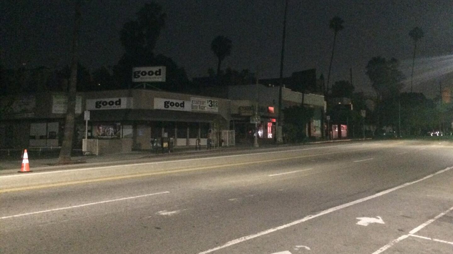 Store lights are out on Sunset Boulevard and Lucile Avenue while street lights are shining.