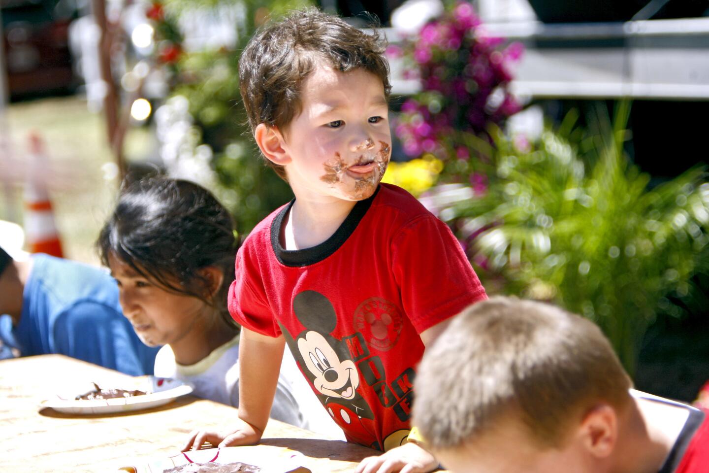 With a face full of chocolate, contestant Jacob Faust, 3 of La Crescenta, stops to look over the competition during the Pie Eating contest at the annual La Crescenta Country Fair, at Crescenta Valley Park in La Crescenta on Saturday, April 29, 2017.