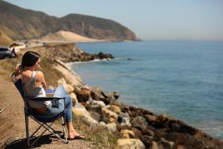VENTURA COUNTY, CA - APRIL 15, 2020 -Miriam Burciga, 27, enjoys a socially distant perch overlooking Point Mugu State Park during days of the coronavirus pandemic along Pacific Coast Highway in Ventura County Ventura on Wednesday, April 15, 2020. Point Mugu State Park has been temporarily closed since April 7 in an effort to prevent visitation surges to help stop the spread of the coronavirus. (Genaro Molina / Los Angeles Times)