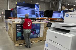 An associate checks over a big-screen television on display in a Costco warehouse Tuesday, Feb. 6, 2024, in Colorado Springs, Colo. On Tuesday, The Labor Department issues its report on inflation at the consumer level in January. (AP Photo/David Zalubowski)
