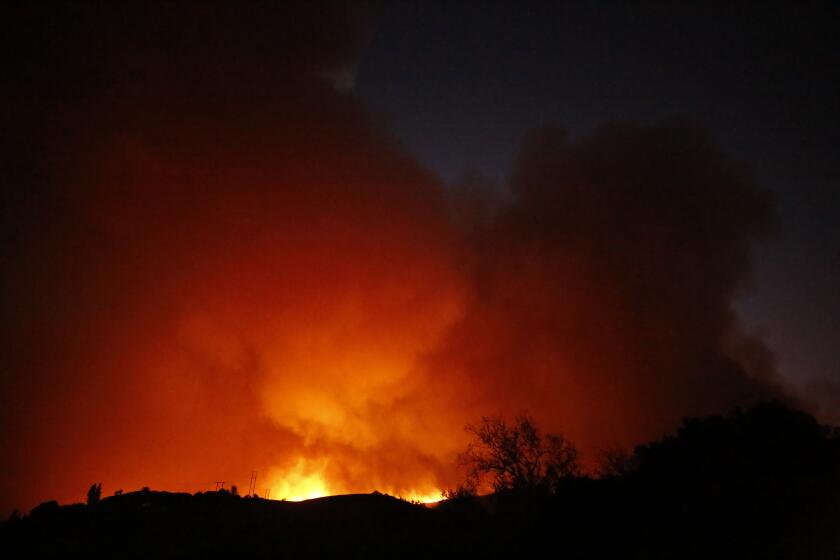 GAVIOTA COAST, CA - OCTOBER 11: Flames light up the night sky as the Alisal Fire quickly grew to over 1,000 acres Monday afternoon driven by sundowner winds as it burned through Tajiguas Canyon to the 101 freeway forcing its closure. Mandatory evacuations are in place as the gusty winds drive flames through rough terrain that hasn't burned in decades. The 1955 Refugio Fire that consumed 80,000 acres is the last time much of the area had burned. The historic Reagan Rancho del Cielo which sits near the top of Refugio Canyon could be threatened by the flames as the fire moves into Refugio Canyon. Refugio Road on Monday, Oct. 11, 2021 in Gaviota Coast, CA. (Al Seib / Los Angeles Times).