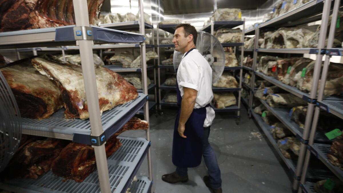 Chef Adam Perry Lang inspects his environmental chamber where his dry aging beef is stored at APL restaurant in Hollywood.