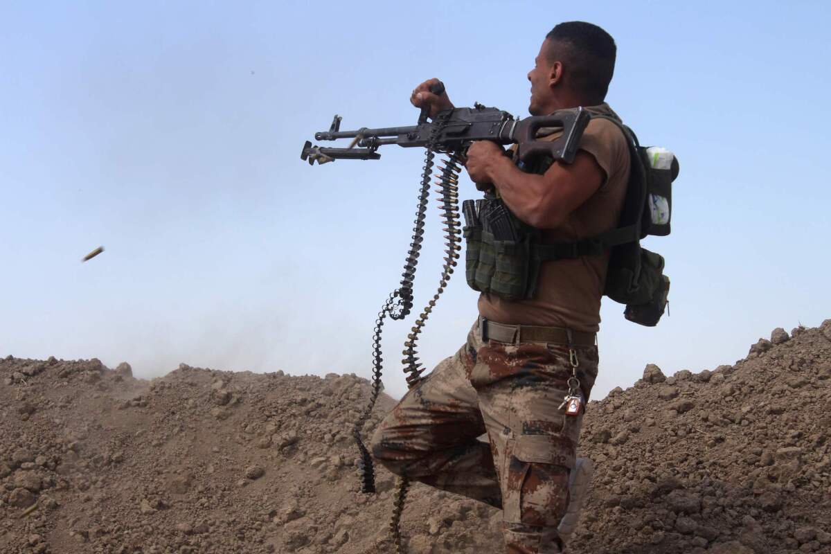 A member of the Iraqi pro-government forces fires his weapon on a front line in the Albu Huwa area, south of Fallouja, Iraq, near the Euphrates River, on May 31, 2016, during an operation aimed at retaking areas from the Islamic State group.