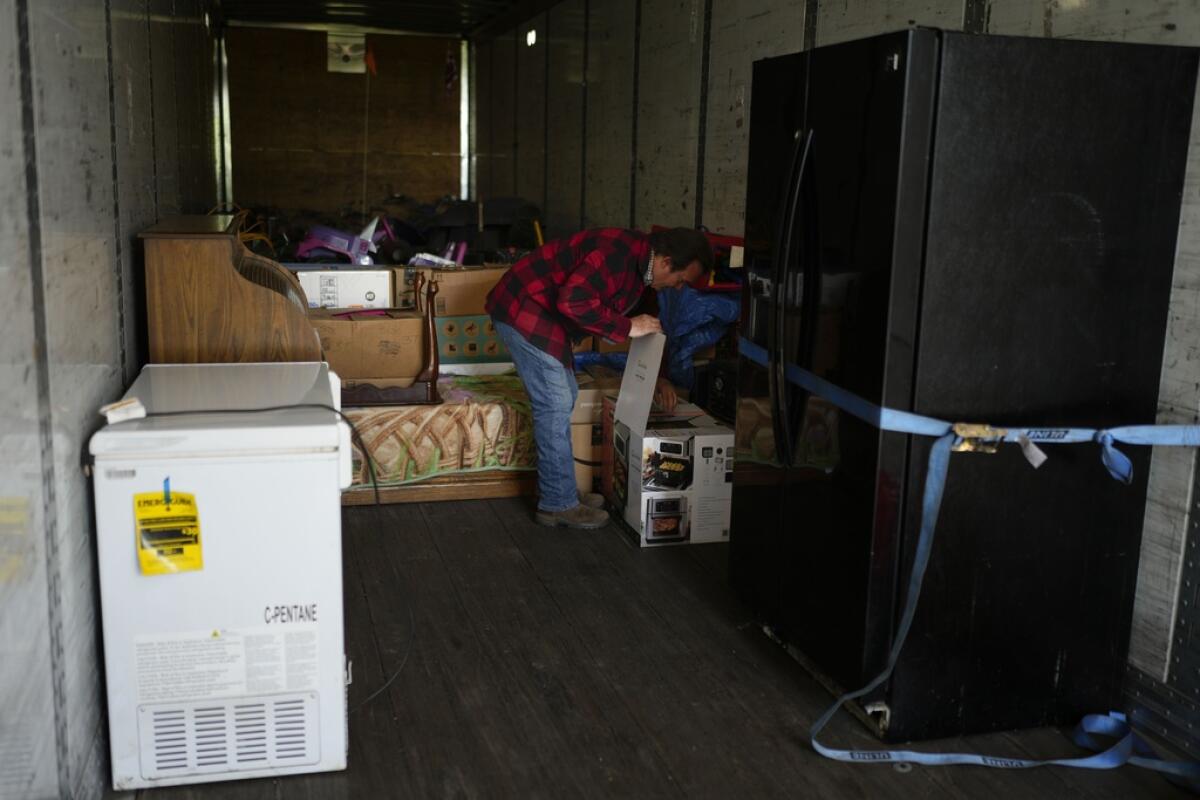 Ron Caetano abre una caja en un tráiler donde colocó las pertenencias
