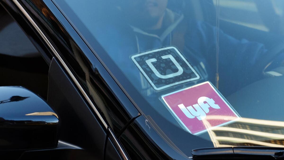 A car window with Uber and Lyft signs