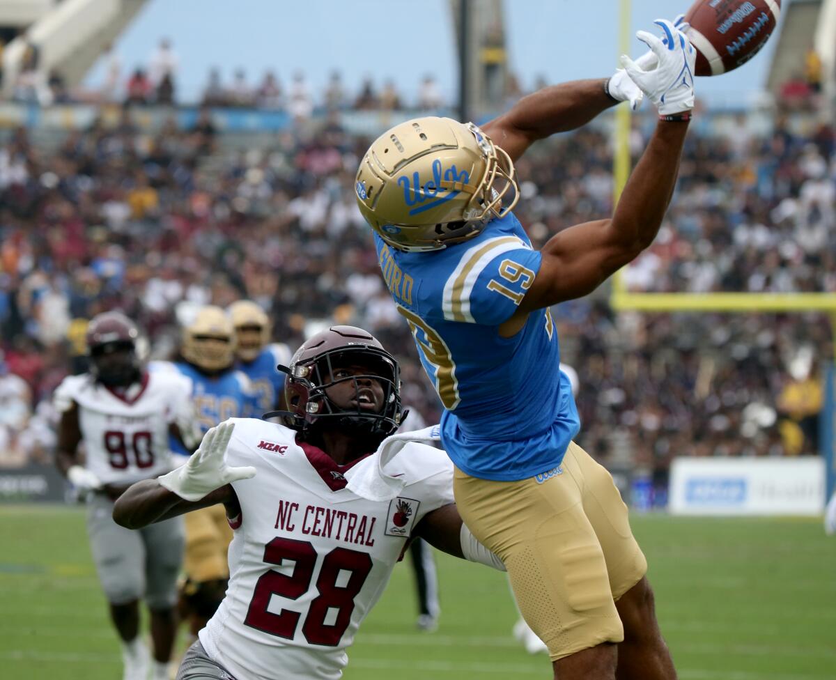 UCLA wide receiver Kyle Ford tries to catch a pass over North Carolina Central cornerback Jason Chambers.