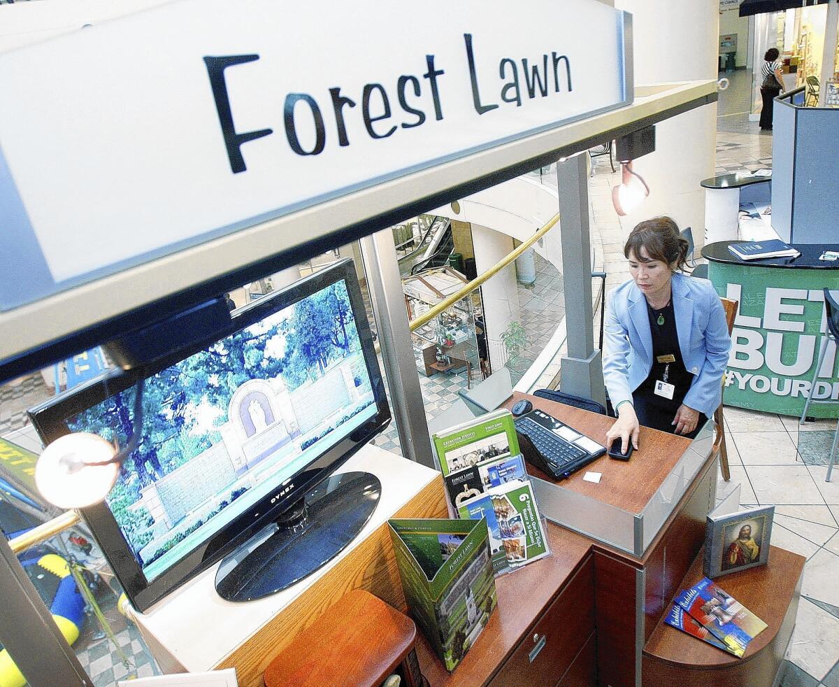 Yoon Lee, of Forest Lawn, at a recently set up information-only kiosk for Forest Lawn at the Burbank Town Center on Tuesday, Feb. 18, 2014. There are two other kiosks set up at Glendale Galleria and the Eagle Rock Plaza.