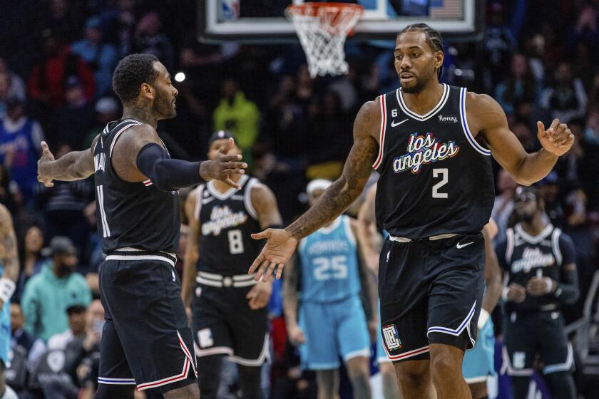 LA Clippers guard John Wall and forward Kawhi Leonard (2) celebrate after taking the lead against the Charlotte Hornets during the second half of an NBA basketball game on Monday, Dec. 5, 2022, in Charlotte, N.C. (AP Photo/Scott Kinser)