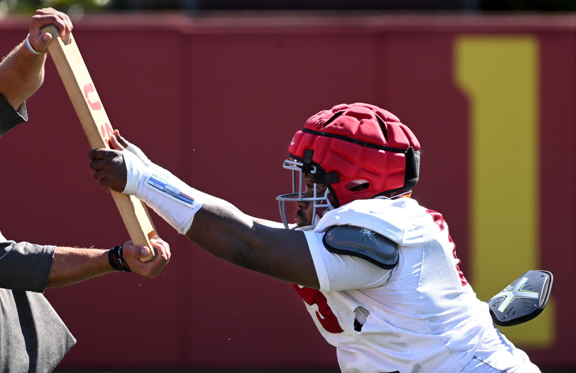 USC defensive lineman Bear Alexander pushes a board during football practice