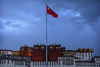 FILE - The Chinese flag flies at a plaza near the Potala Palace in Lhasa in western China's Tibet Autonomous Region, on June 1, 2021, as seen during a government organized visit for foreign journalists. China has sanctioned two U.S. individuals in retaliation for action taken by Washington over human rights abuses in Tibet, the government said Friday, Dec. 23, 2022, amid a continuing standoff between the sides over Beijing's treatment of religious and ethnic minorities. (AP Photo/Mark Schiefelbein, File)
