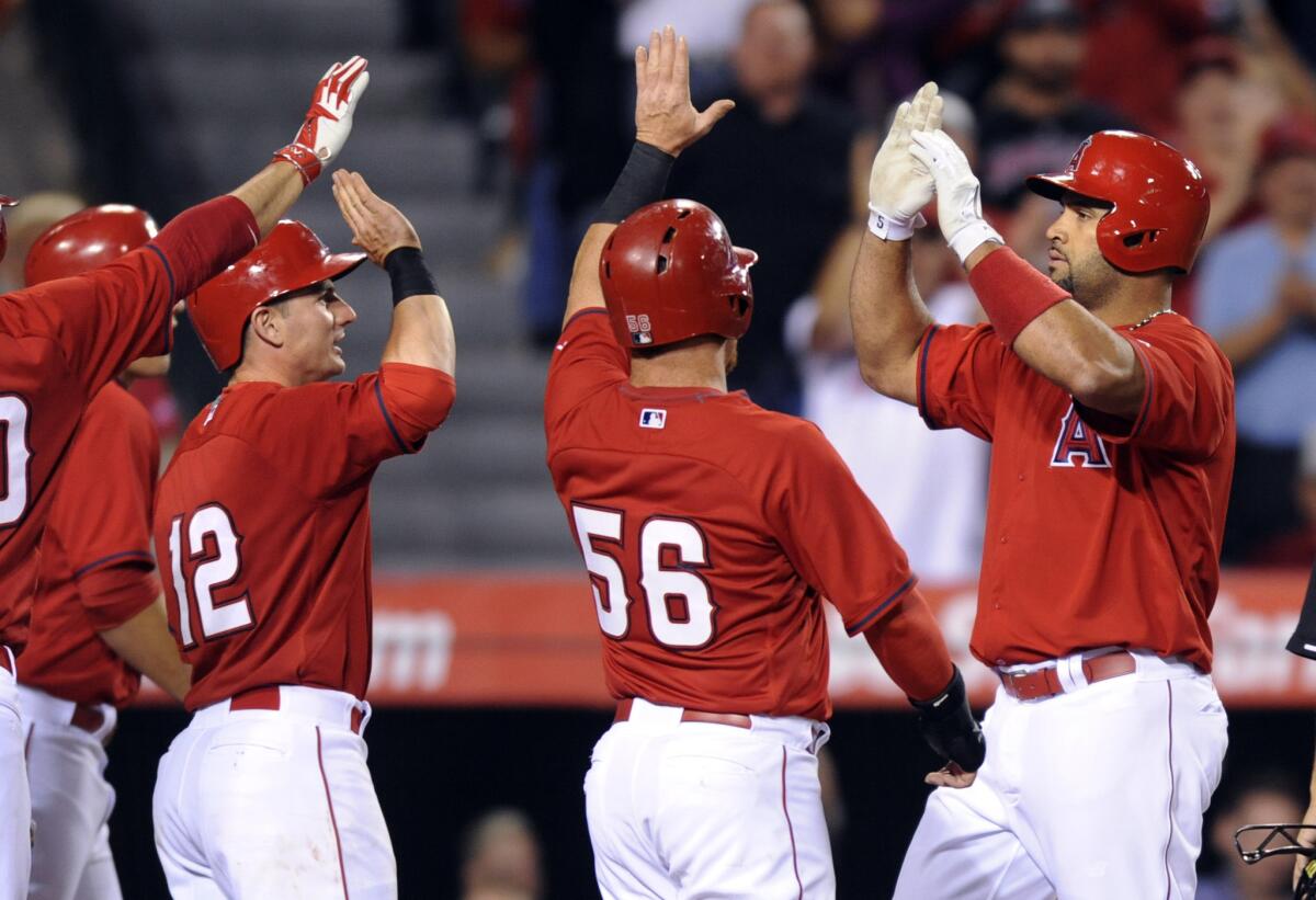 Angels first baseman Albert Pujols, right, is congratulated by teammates after hitting a grand slam against the Dodgers in the fifth inning Friday nigt in Anaheim.