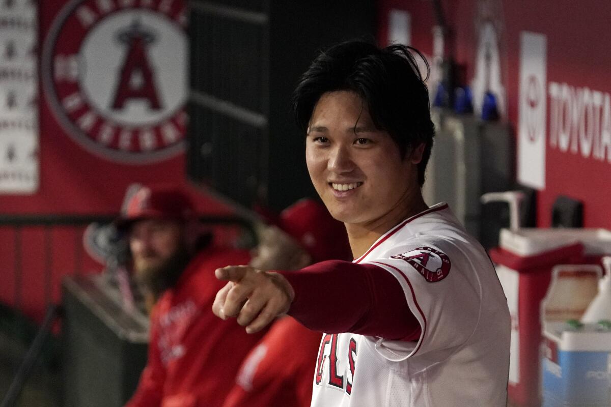 Shohei Ohtani, de los Angelinos de Los Ángeles, gesticula hacia otros jugadores en la banca.