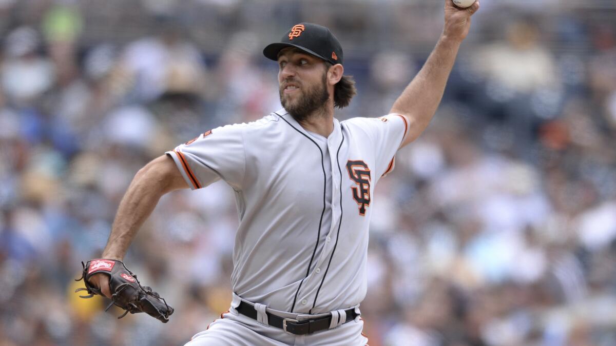 San Francisco Giants starting pitcher Madison Bumgarner touches his beard  as he walks back to the mound while working against the San Diego Padres  during the third inning of a baseball game