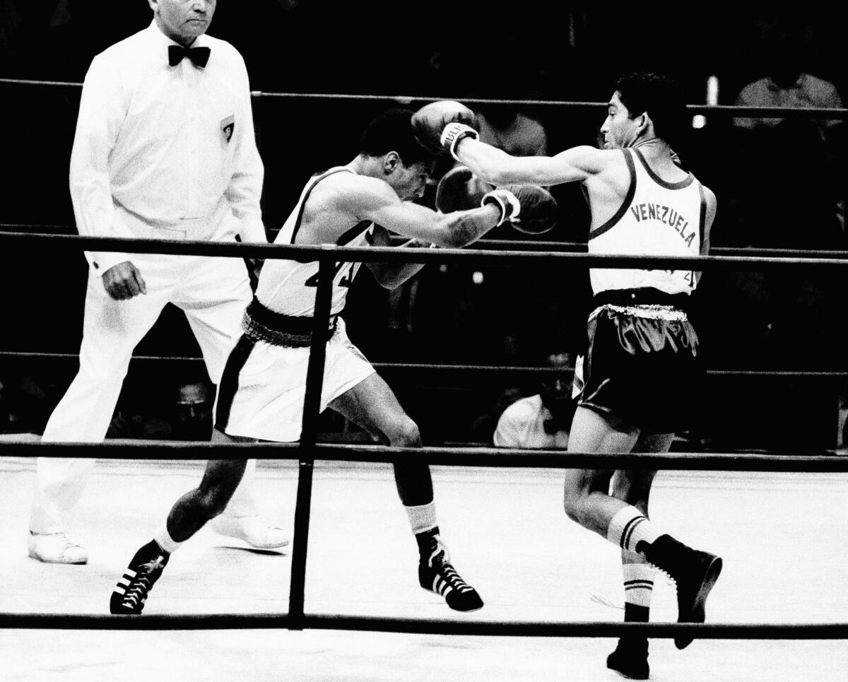 FILE - Francisco Rodriguez of Venezuela, right, throws a left to the head of Harland Marbley of the United States during their light heavyweight Olympic bout in Mexico City, Oct. 25, 1968. Rodriquez won on points. Francisco "Morochito" Rodríguez, who in 1968 won Venezuela's first gold medal at an Olympic Games when he won the light flyweight division, died on Wednesday, April 24, 2024. He was 78. (AP Photo, File)