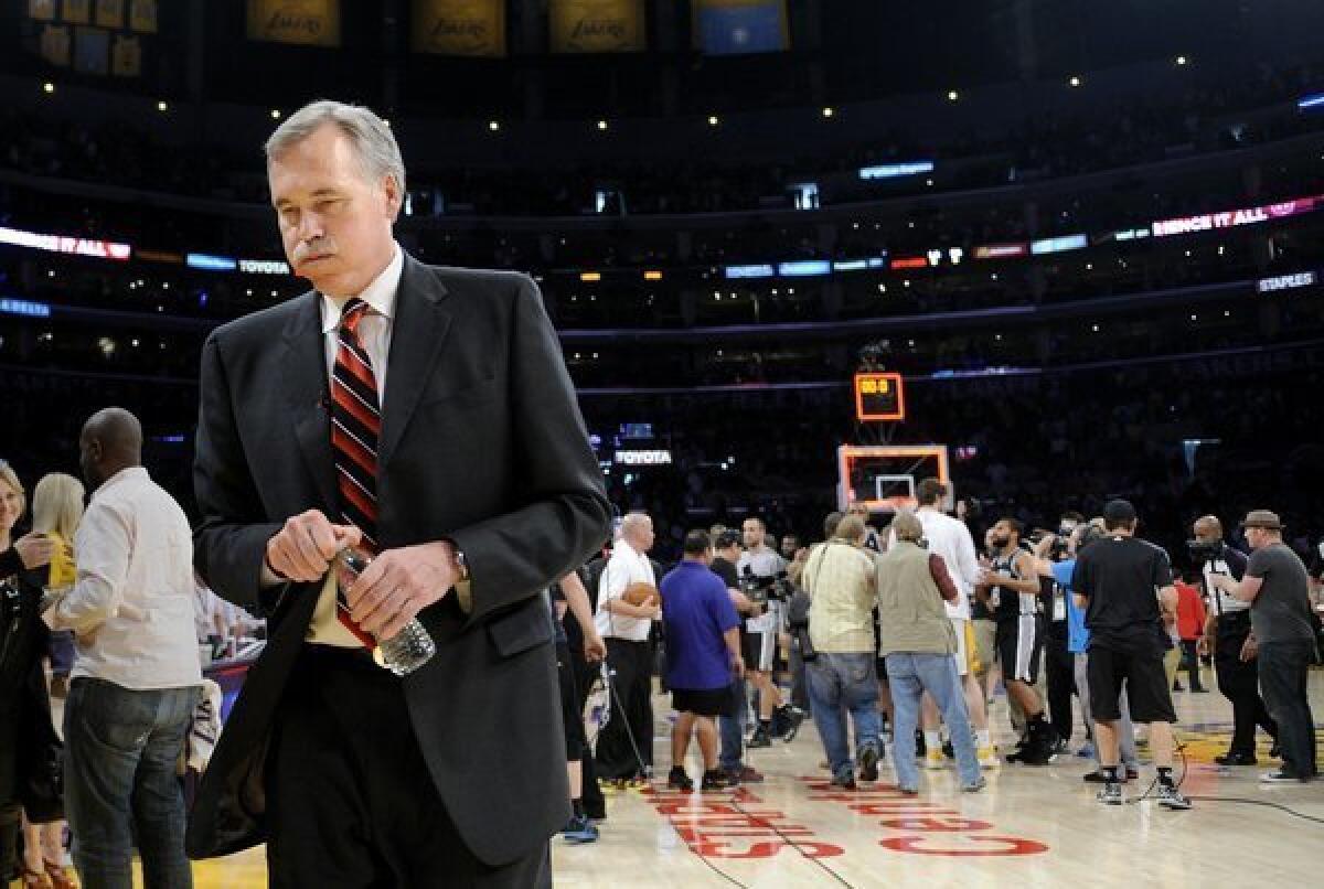 Coach Mike D'Antoni leaves the court after the Lakers were swept out of the playoffs by the Spurs with a Game 4 loss on Sunday.