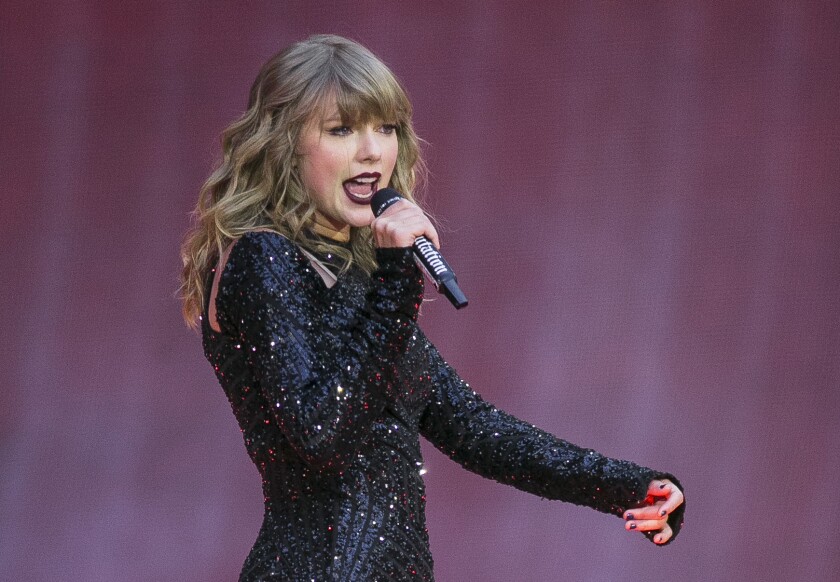 Taylor Swift sings into a microphone.