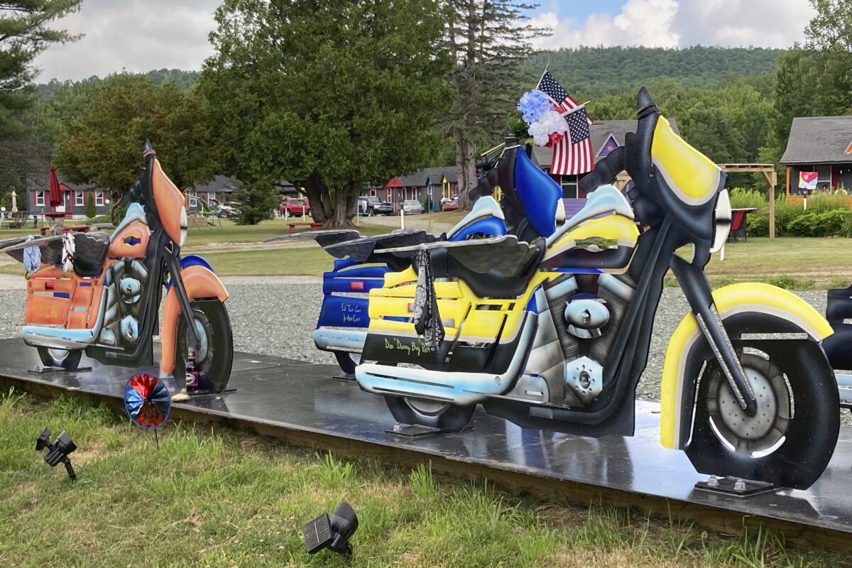 Motorcycle likenesses, part of a memorial to honor members of the Jarheads Motorcycle Club killed in a nearby crash, are visible July 13, 2022, on the roadside in Randolph, N.H. Volodymyr Zhukovskyy, of West Springfield, Mass., is scheduled to face trial on July 26, 2022, on multiple counts of negligent homicide, manslaughter, driving under the influence and reckless conduct stemming from the crash that killed seven motorcyclists that happened in Randolph on June 21, 2019. (AP Photo/Kathy McCormick)