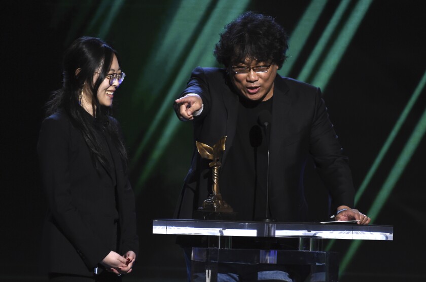 Bong Joon Ho accepts an Independent Spirit Award with interpreter Sharon Choi at his side.