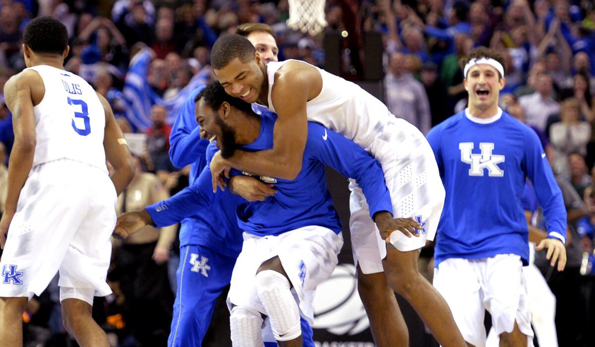 Kentucky players celebrate after a 68-66 win over Notre Dame in the NCAA tournament's Midwest Regional final on Saturday left them with a 38-0 record and a spot in the Final Four.