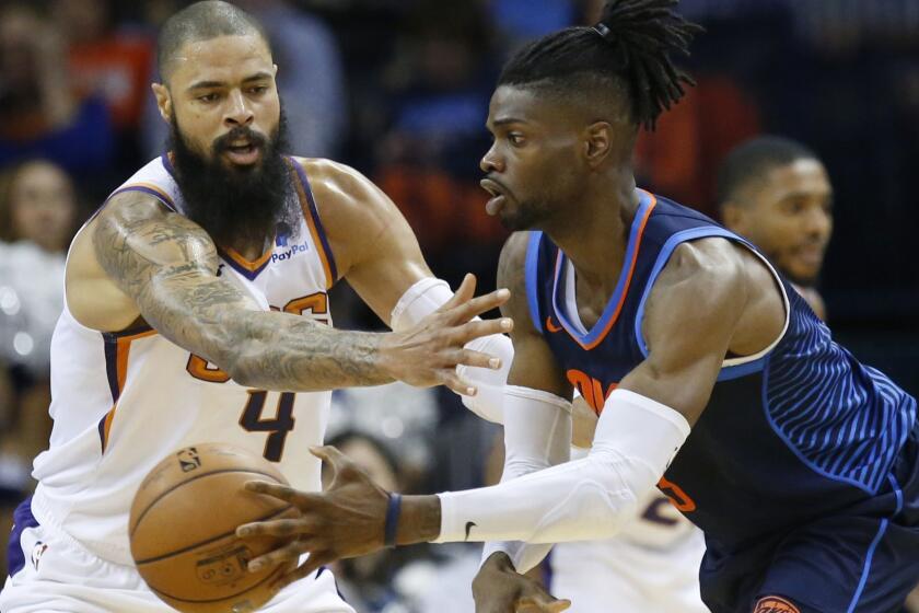 Oklahoma City Thunder forward Nerlens Noel, right, passes in front of Phoenix Suns center Tyson Chandler (4) in the first half of an NBA basketball game in Oklahoma City, Sunday, Oct. 28, 2018. (AP Photo/Sue Ogrocki)