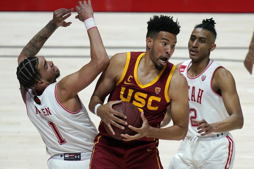 Southern California forward Isaiah Mobley, center, pulls down a rebound as Utah's Timmy Allen (1) and Ian Martinez.