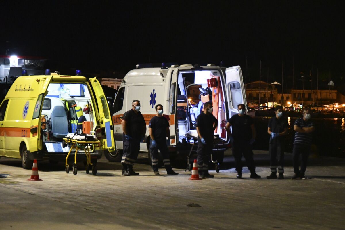 Paramedics wait next to ambulances at Pythagorio port, on the eastern Aegean island of Samos, Greece, late Monday, Sept. 13, 2021. A small private plane crashed into the sea off Greece's eastern Aegean Sea island of Samos late Monday killing both people on board, the Greek coast guard said. State ERT TV said the victims were a man and a woman from Israel who had been planning to visit the island. There was no information on their identities. (AP Photo/Michael Svarnias)